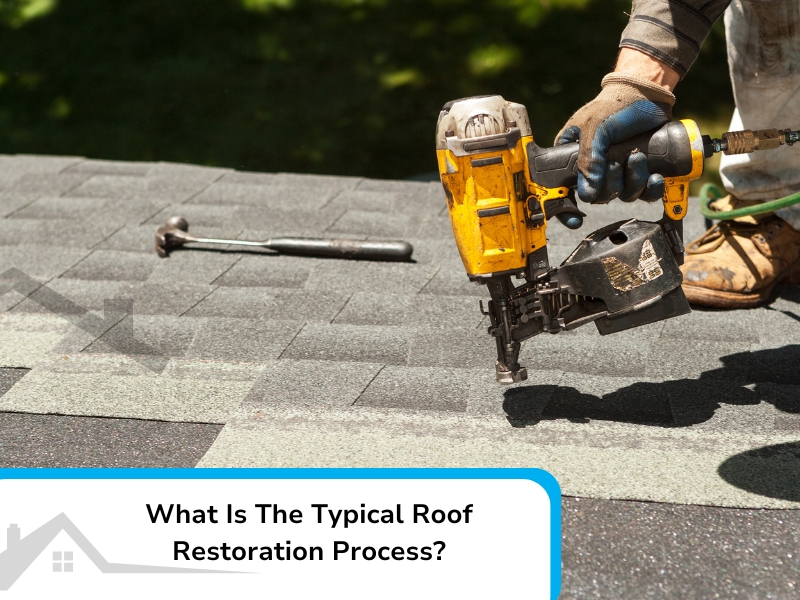 Roofer using a nail gun during a roof restoration process, installing new shingles on a roof.