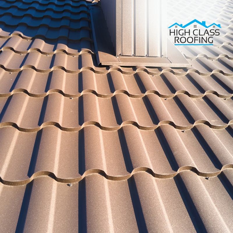 Metal Roof Painting: Close-up of a freshly painted metal roof with wavy panels reflecting sunlight, showcasing professional finishing.